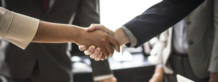 Two business persons shaking hands.