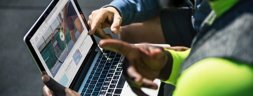 Two people discussing what is displayed on a laptop.