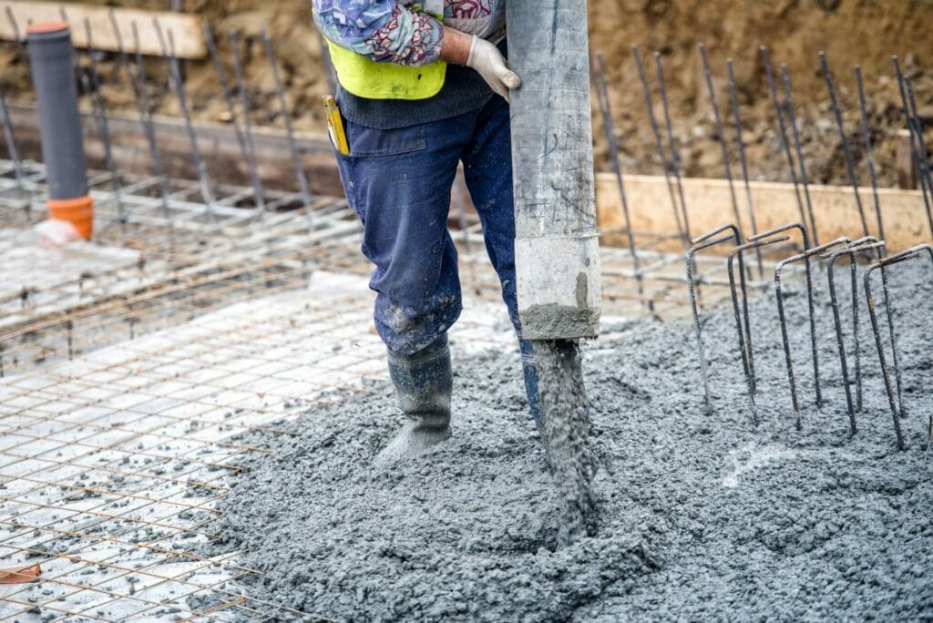 Construction Working pouring concrete into a foundation