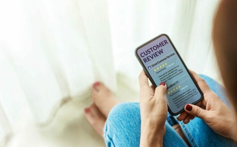 Person looking at cell phone displaying Customer Review