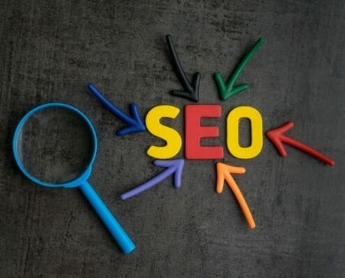 Colourful graphic with SEO letters surrounded by coloured arrows and magnifying glass