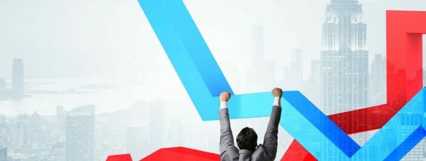 A man hanging onto the a blue up-trend arrow with a red down-trend arrow behind and the New York skyline