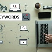 Graphic layout of SEO keywords with man searching on laptop computer