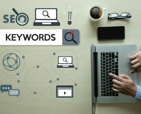Graphic layout of SEO keywords with man searching on laptop computer