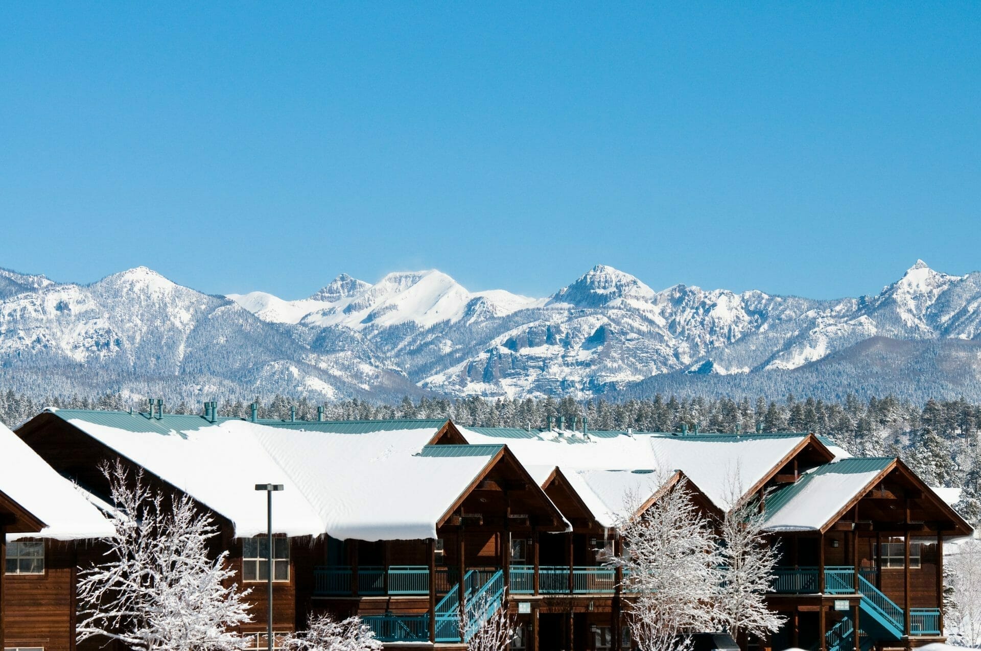 Whistler type townhomes with snow covered trees and mountains in the background