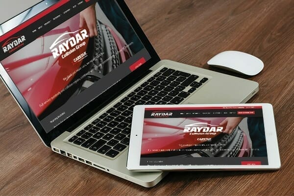 Tablet & laptop screens showing Raydar Collision Group website HOME page