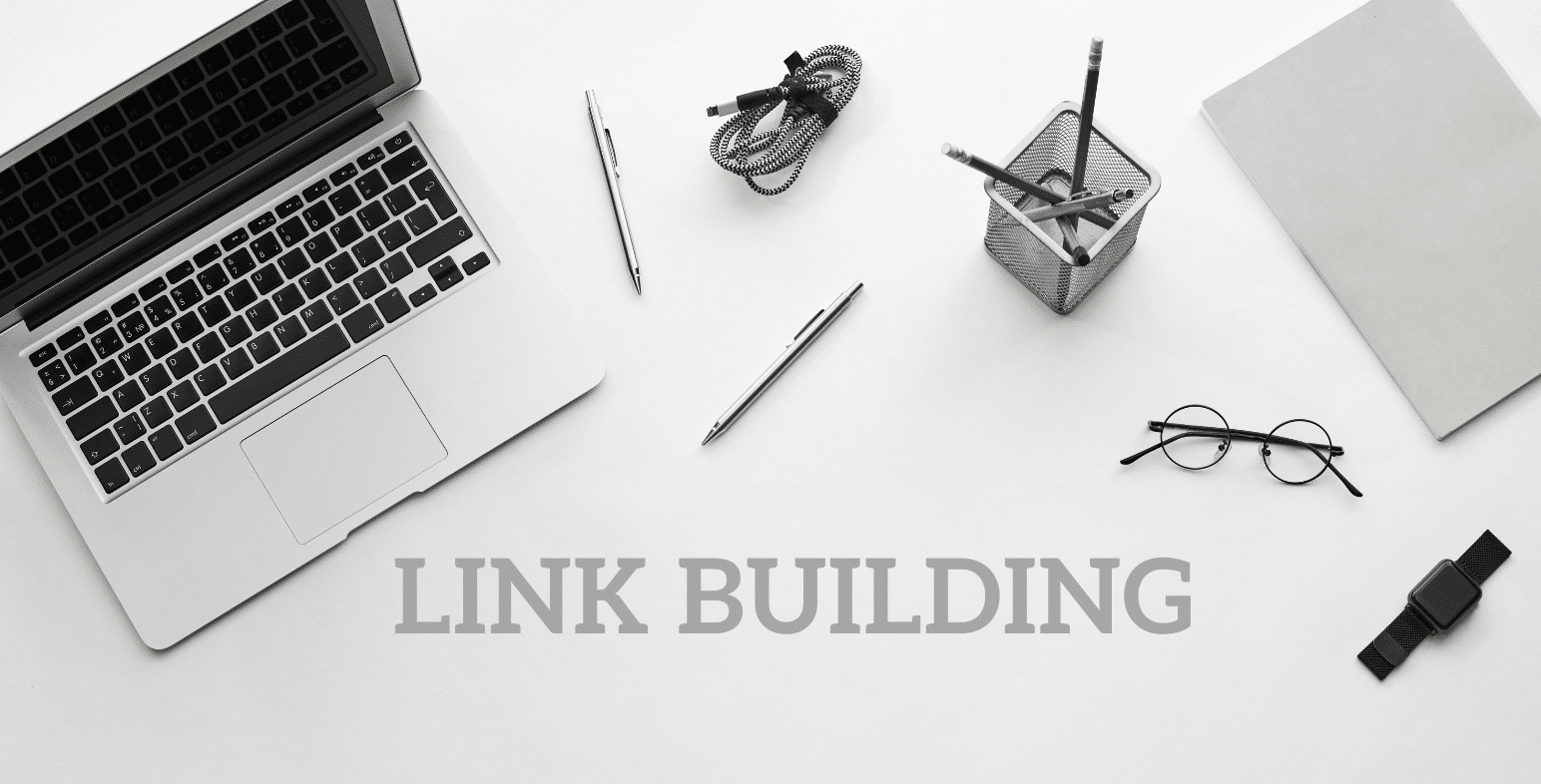 Laptop, pens, pencils, watch and eyeglasses with the words Link Building