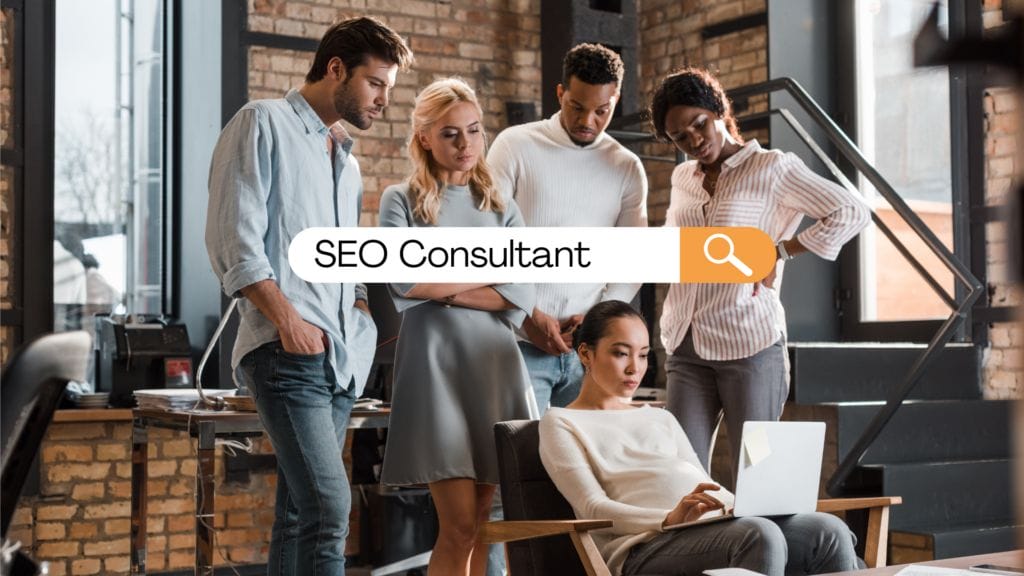 Woman sitting with a laptop with 4 people looking over her shoulder