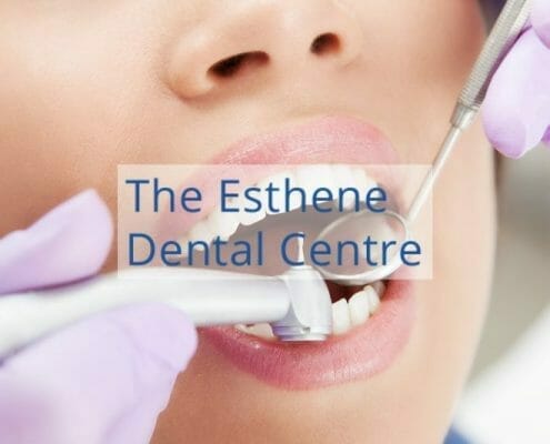 The Esthene Dental Centre featured image showing dentist checking a patient's teeth.