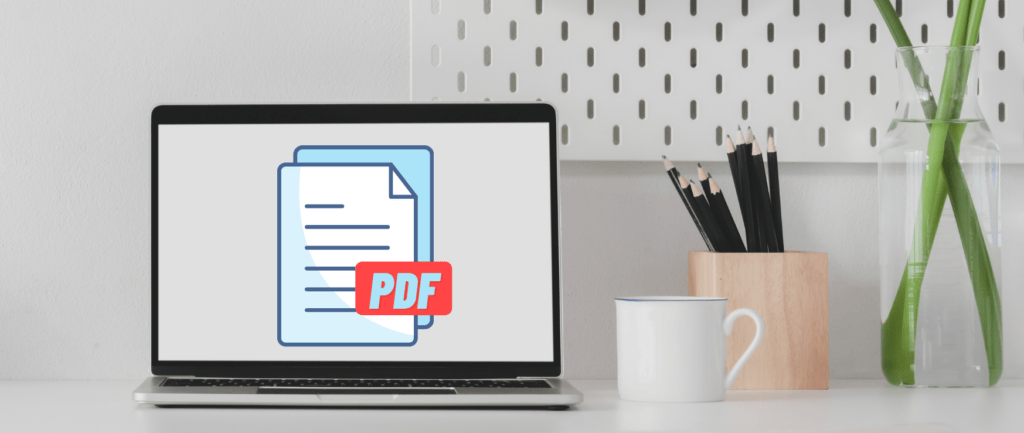 Laptop displaying PDF graphic next to a coffee cup and a pencil holder.