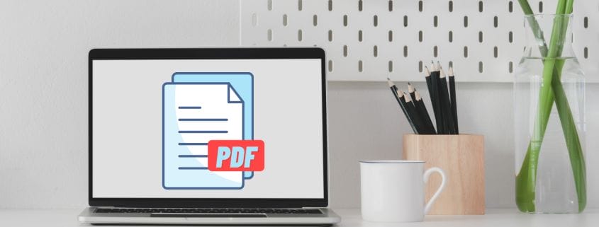 Laptop displaying PDF graphic next to a coffee cup and a pencil holder.
