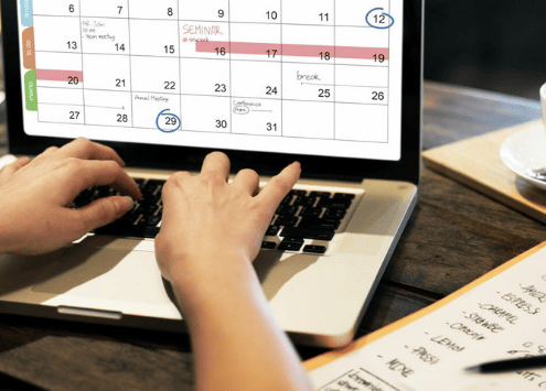 Person with a laptop working on a calendar