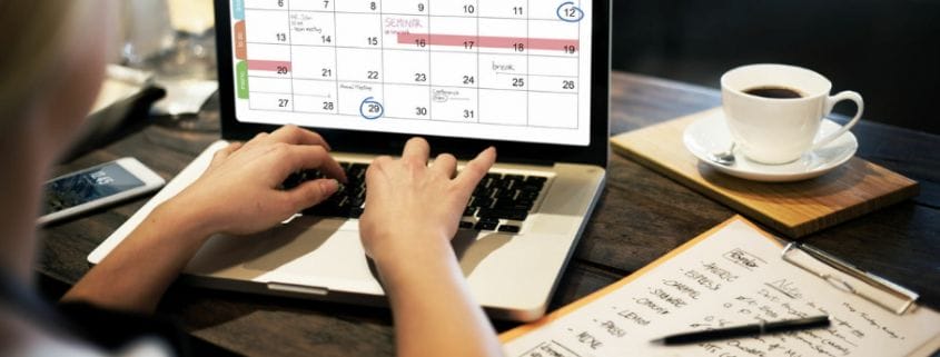 Person with a laptop working on a calendar