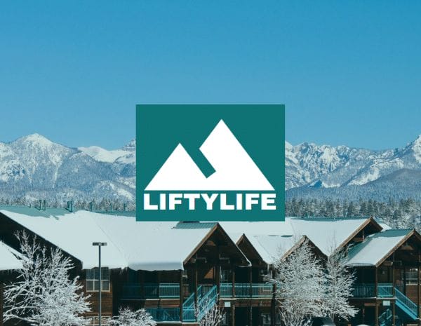 Liftylife logo over a image of homes covered in snow with snow-capped mountains in the background.