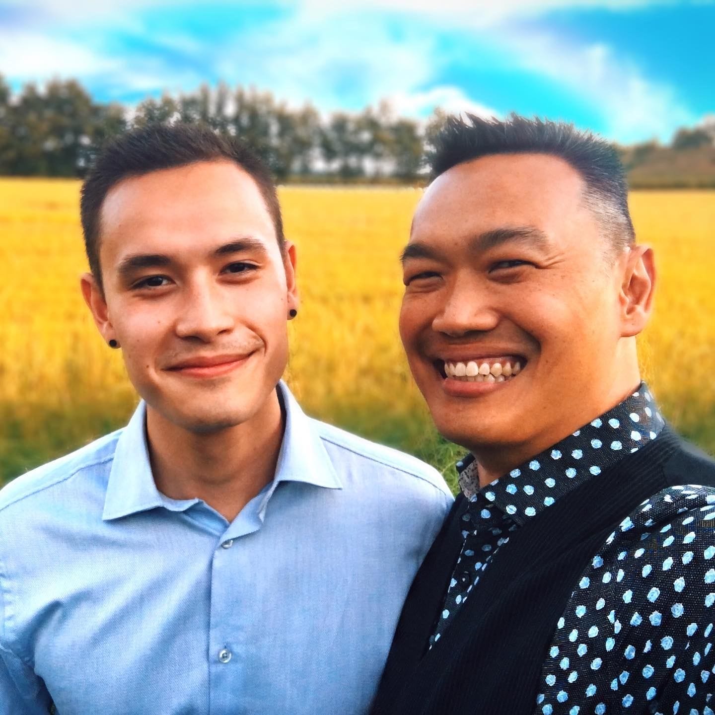 Sherman Hu posing in a field with his son
