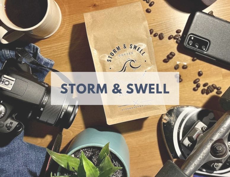 Storm & Swell brand name over an image of a bag of their coffee surrounded by a camera, smartphone, coffee, etc.