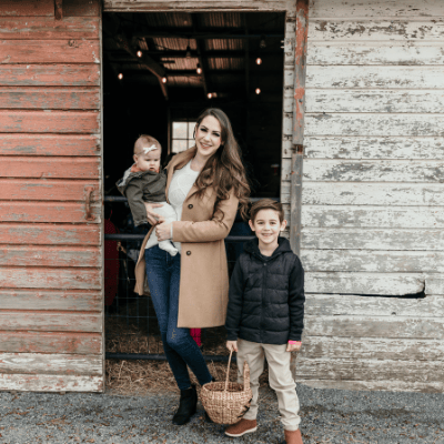 Woman and 2 children standing by a barn door