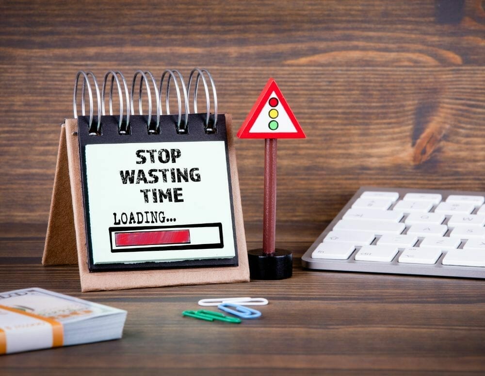 Desk with a flip chart that says Stop Wasting Time