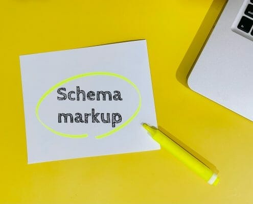 Paper with the words schema markup on a yellow desk