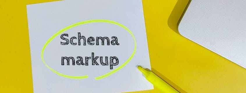 Paper with the words schema markup on a yellow desk