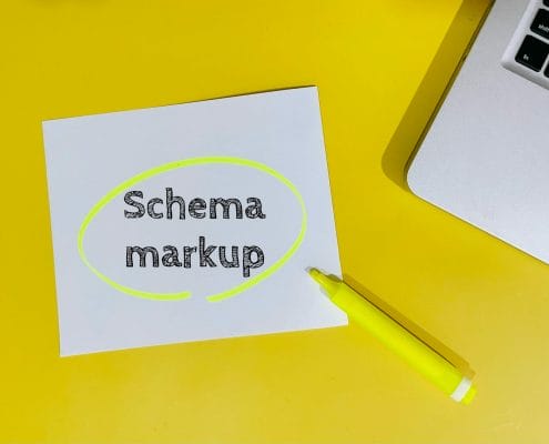 Paper with the words schema markup on a yellow desk
