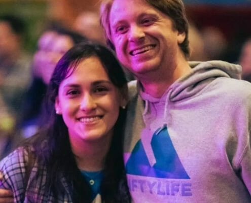 A man in a Liftylife hoodie embracing a young women at a public event.