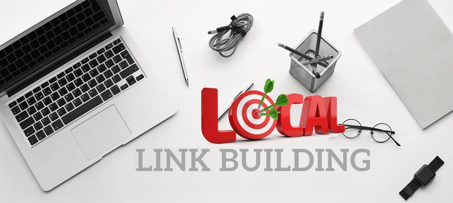 A laptop sits open on a desk next to a coiled cable, pen, and glasses. A red 3D text "LOCAL" with a target and green sprout is next to "LINK BUILDING" written below. Office supplies and a notebook are around. The scene is in black and white.