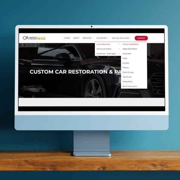 A computer display shows a website for custom car restoration. The webpage features a dark car image and a menu bar with navigation options including contact and locations like Coquitlam, Maple Ridge, and Surrey. The background is a teal wall.