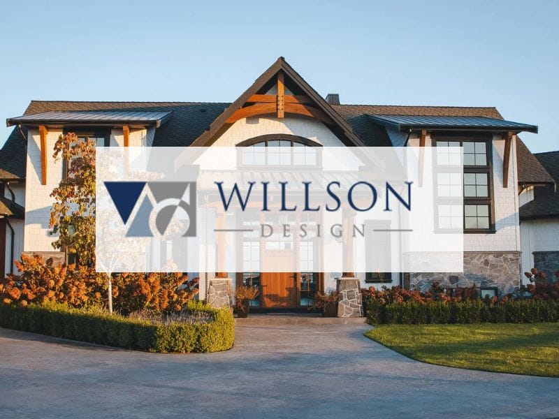 Modern house with a stone exterior, large windows, and a sloped roof, surrounded by manicured landscaping. A logo with "Willson Design" overlays the image.