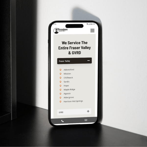 A smartphone displaying a webpage on a white surface. The screen shows a list of locations under "Fraser Valley," including Abbotsford, Mission, and more. The top reads "We Service The Entire Fraser Valley & GVRD.